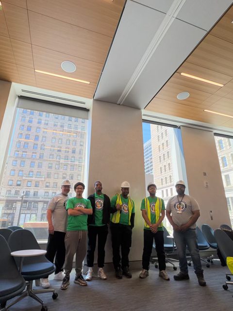 Seminar group in hard hats and safety vests standing together in a classroom
