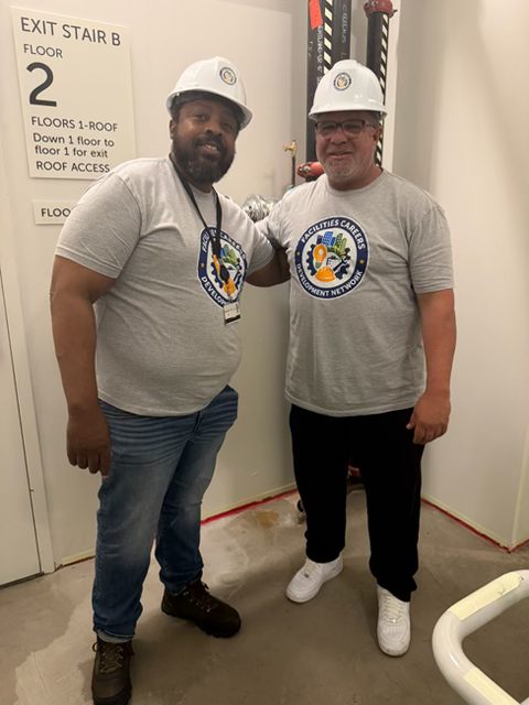 Two Facilities Careers Development Network instructors in hard hats inside a facility