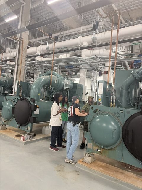 Instructor leading trainees through a chiller plant mechanical room