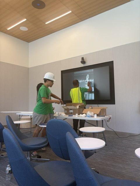 Trainees reviewing a plumbing diagram on the classroom display